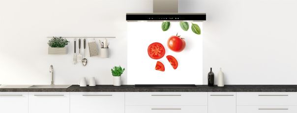 Un fond de hotte très épuré avec une tomate entière, des quartiers de tomate et quelques feuilles de basilic